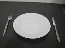 Foto von einem Porzellanteller mit Metallbesteck Foto von einem Porzellanteller mit Metallbesteck